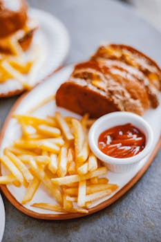Tasty french fries served with ketchup on a plate, perfect for food photography.
