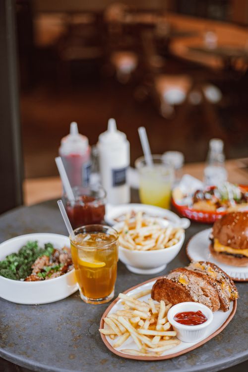 Free Appetizing fast food spread with burgers, fries, and drinks on a table, perfect for dining visuals. Stock Photo