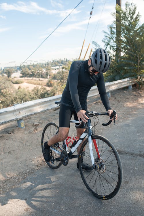무료 빨간색과 검은 색 산악 자전거를 타는 검은 색 긴 소매 셔츠를 입은 남자 스톡 사진