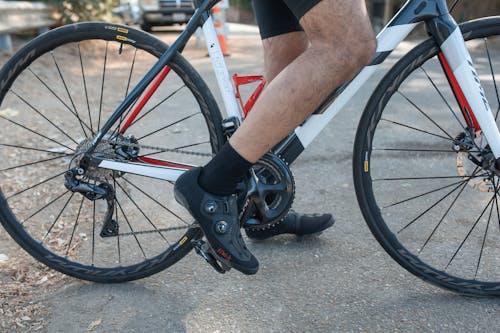 무료 빨간 자전거를 타고 검은 색과 회색 하이킹 신발을 착용하는 사람 스톡 사진