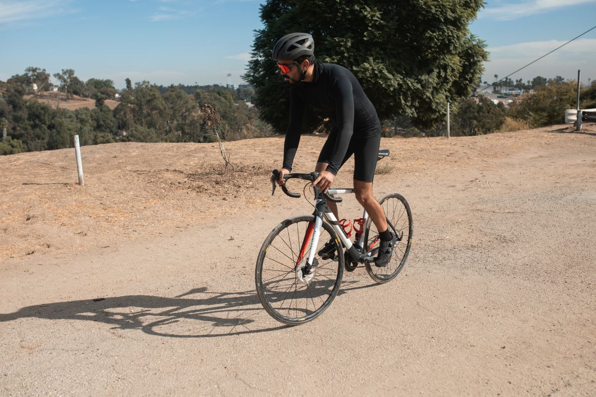 Man riding a bicycle on a road surrounded by nature