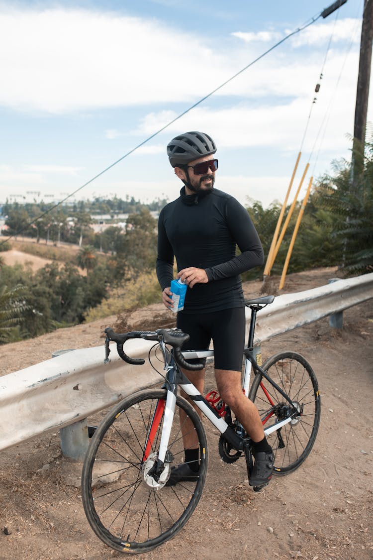 A Man Riding His Bicycle Stopping For A Drink