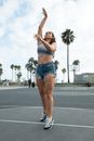 Woman in White Tank Top and Blue Denim Shorts Raising Her Hands