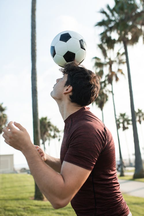 Man Playing a Football on His Head