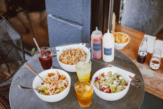 Enjoy a casual meal with fresh salads and cold drinks in an outdoor setting.