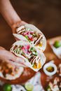 A Person Holding Tortilla Wraps with Lettuce and Beef