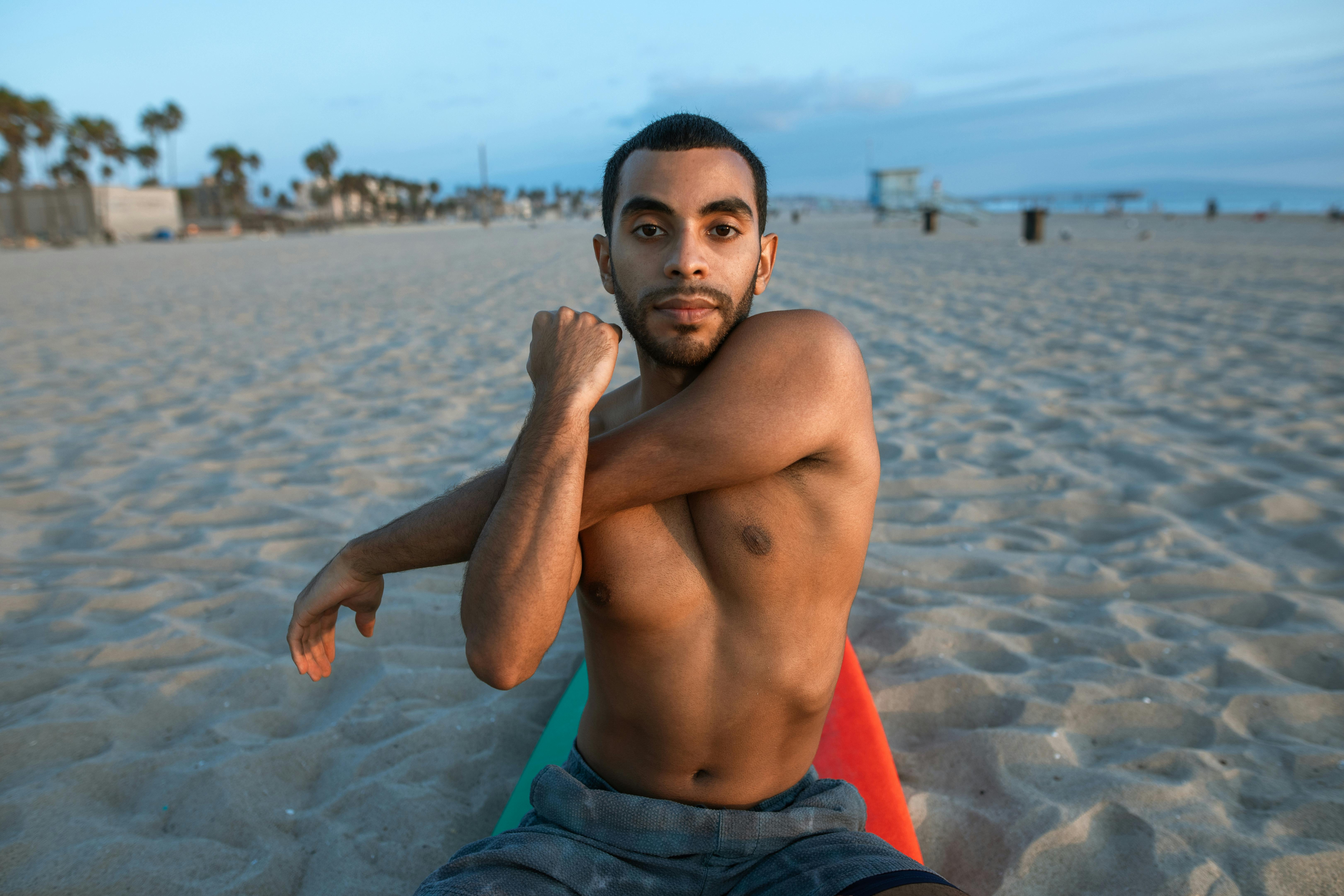 a surfer sitting on a surfboard stretching