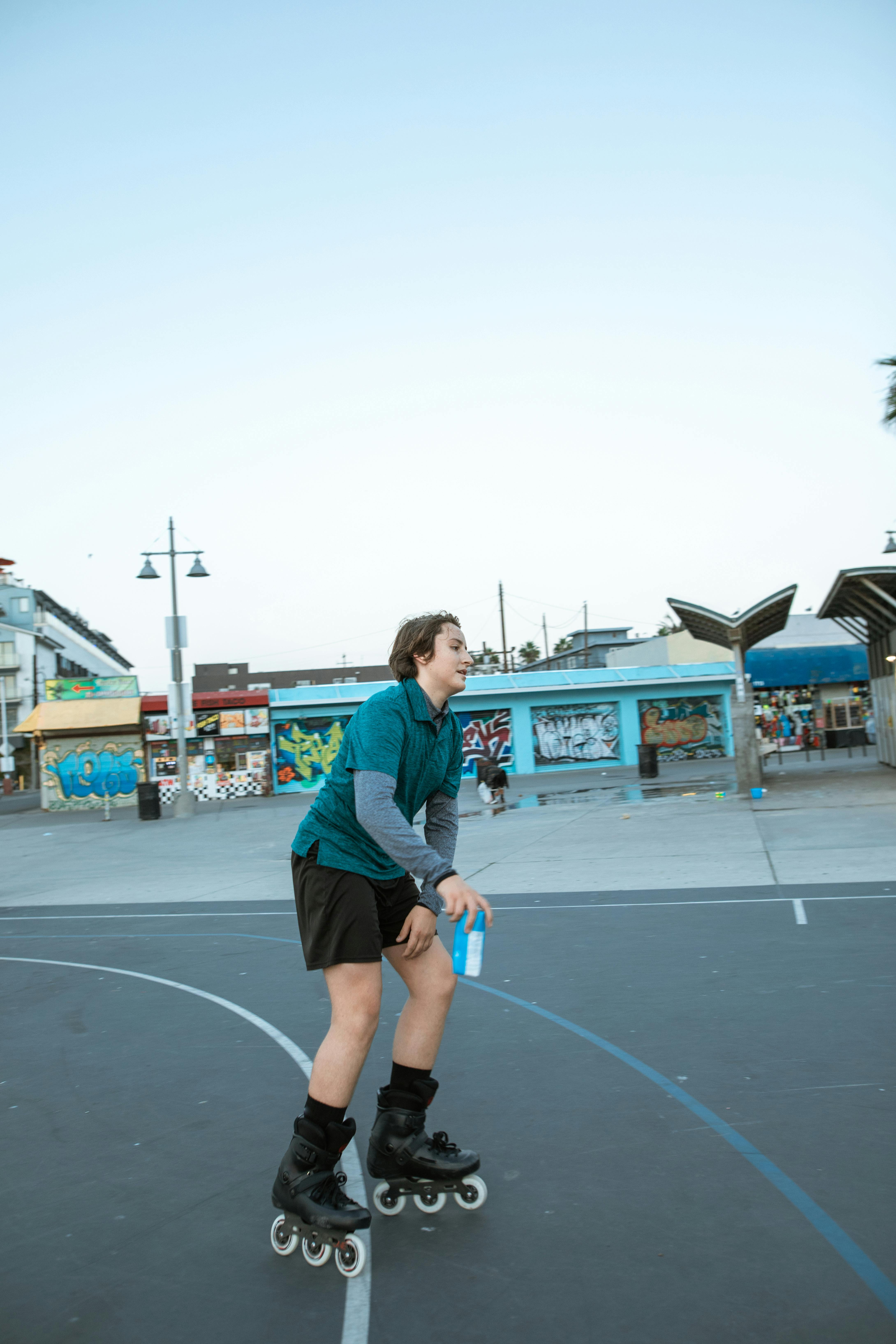 a young rollerblading while holding a jar