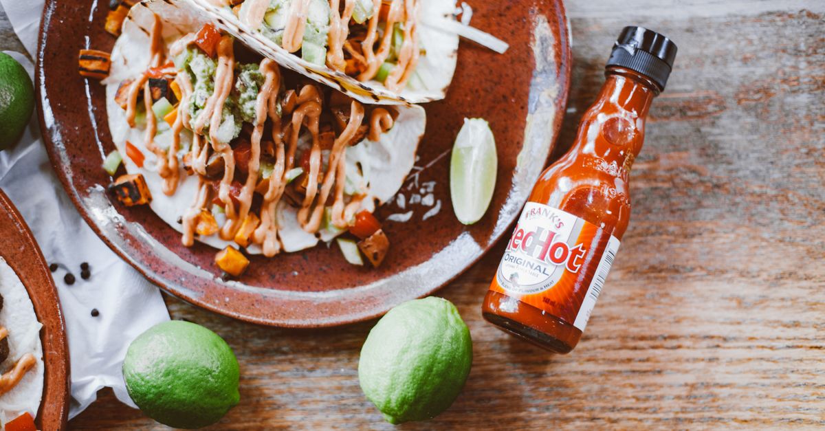 birria tacos with consommé dipping sauce on a rustic wooden table