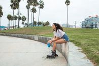 Woman in White T-shirt and Blue Denim Shorts Sitting on Concrete Bench