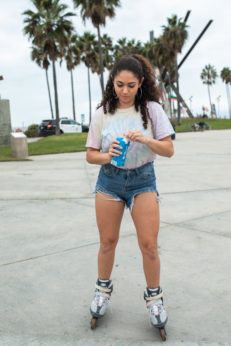 Woman On Rollerblades Holding A Drink