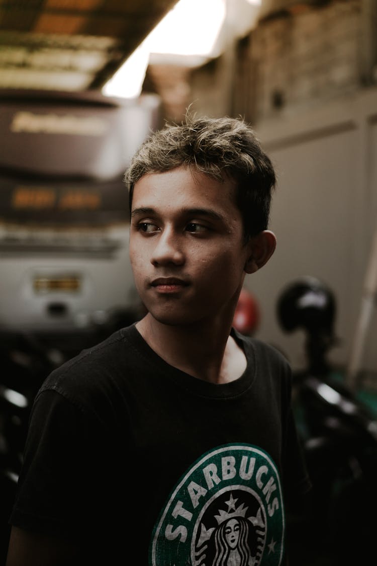 Positive Young Male Millennial Looking Away In Garage