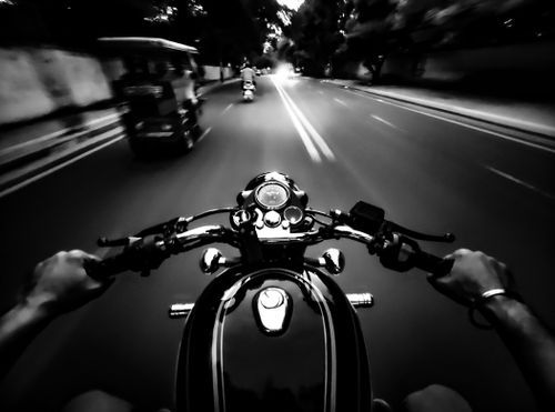 Free Thrilling POV shot of riding a classic motorbike on an open road in black and white. Stock Photo