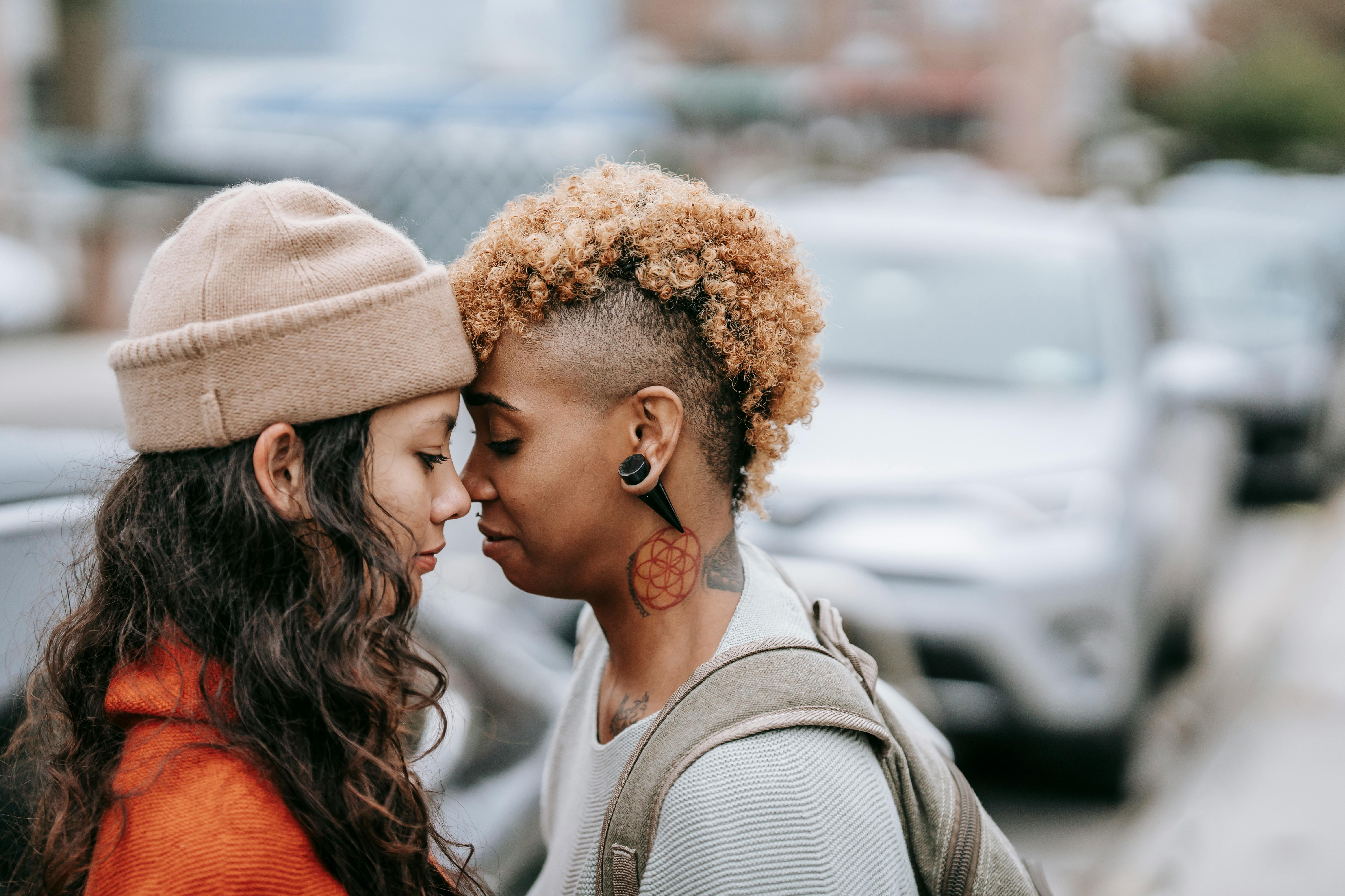 multiracial lesbian couple standing close on city street