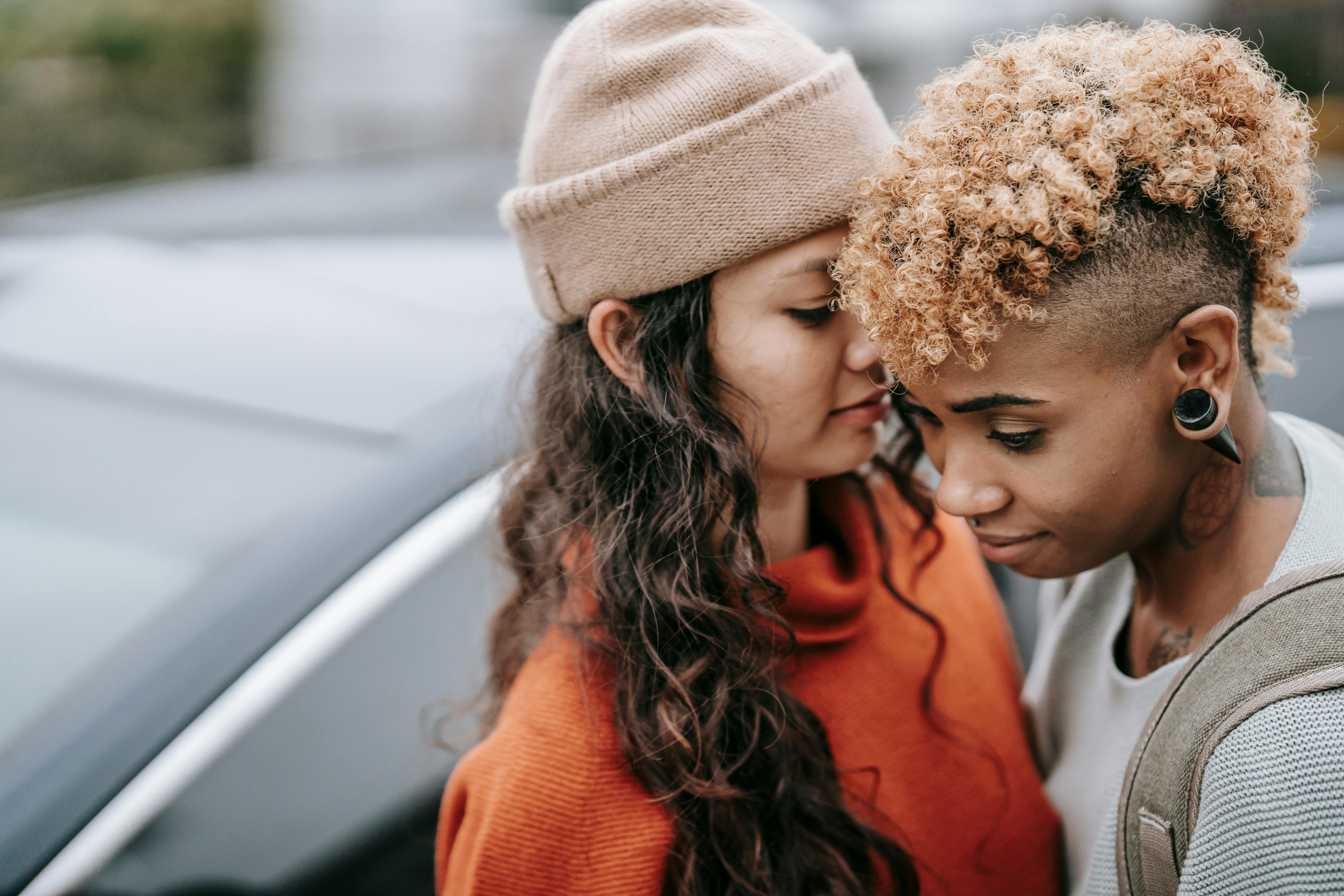 ethnic woman standing close to black beloved on street