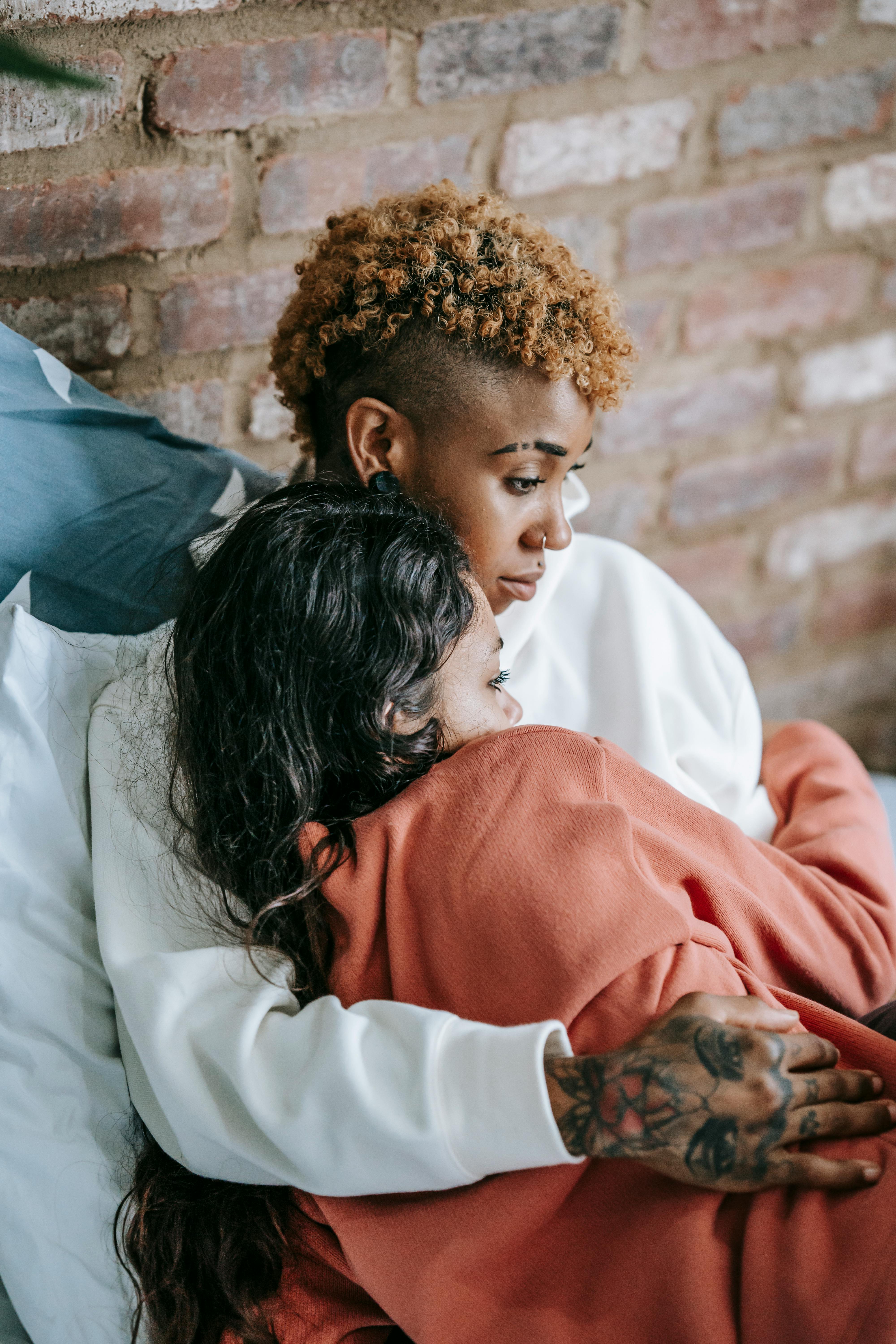 Multiethnic couple of lesbian women cuddling on bed · Free Stock Photo