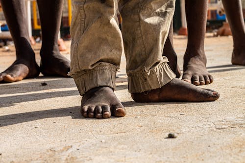 Close-up of Men Standing Barefoot on the Ground 