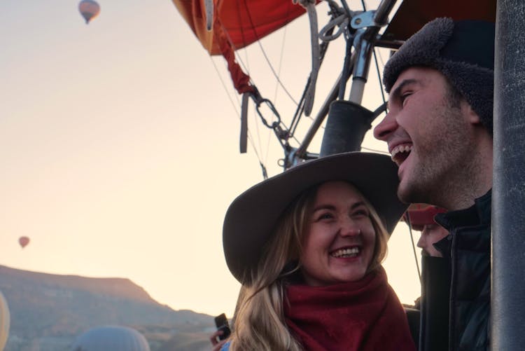 Overjoyed Couple In Hot Air Balloon In Sky