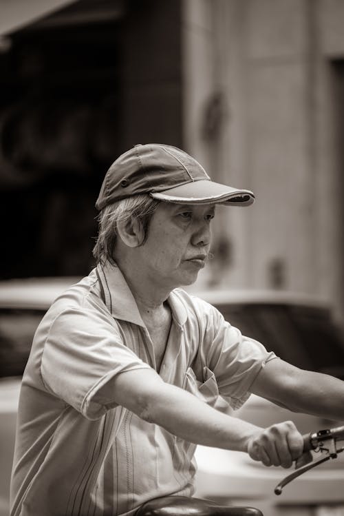 A Grayscale Photo of an Elderly Man Wearing a Cap