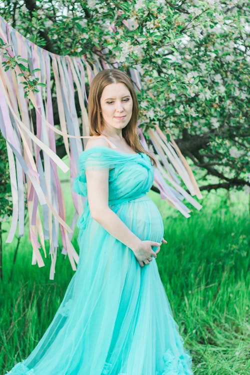 Woman in White Long Sleeve Dress Showing Baby Bump · Free Stock Photo