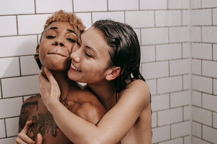 Loving Asian Woman Hugging Naked Black Girlfriend In Shower