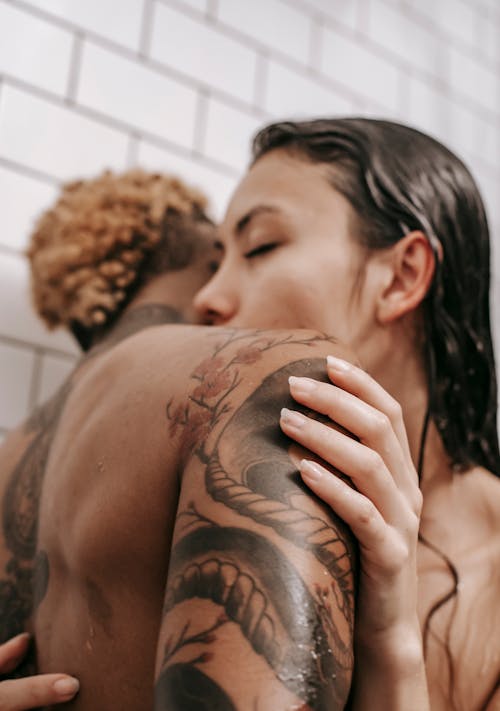 Free Intimate diverse couple kissing in bathroom Stock Photo