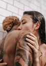 Intimate diverse couple kissing in bathroom