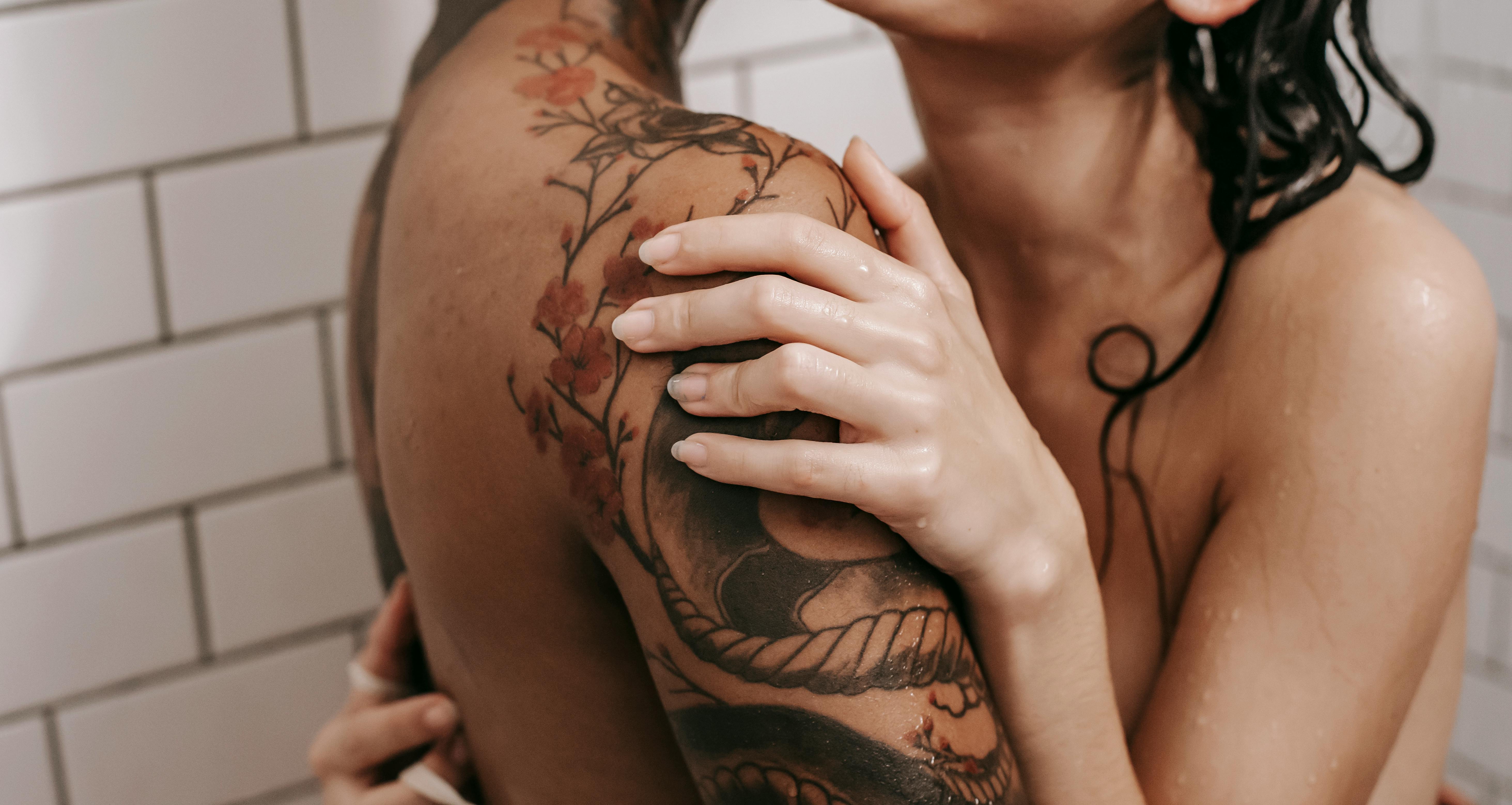 erotic diverse couple embracing in shower