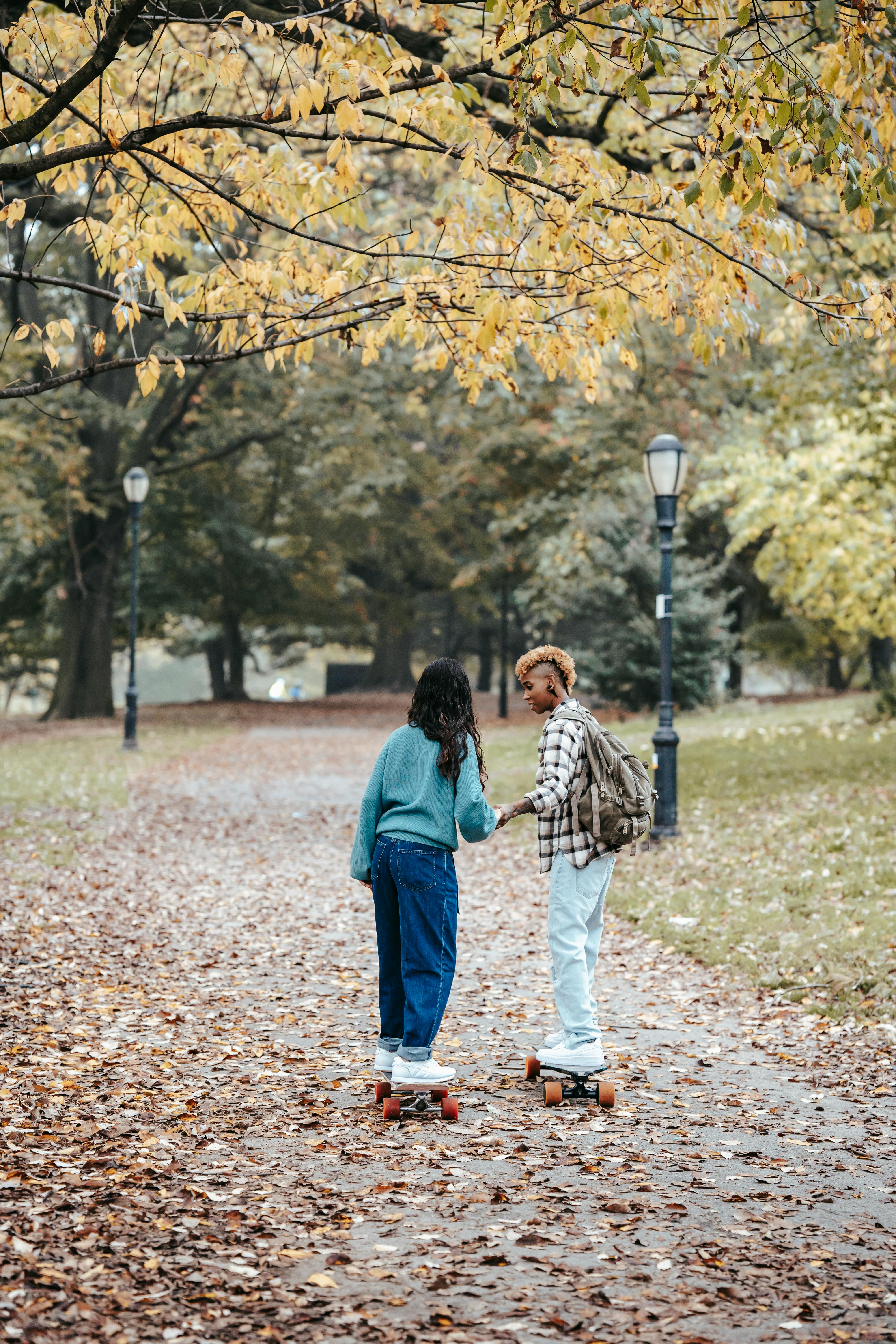 multiethnic homosexual couple enjoying active hobby in autumnal park