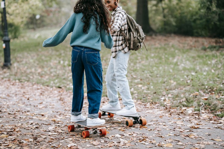 Cheerful Diverse Same Sex Couple Riding Longboards Together