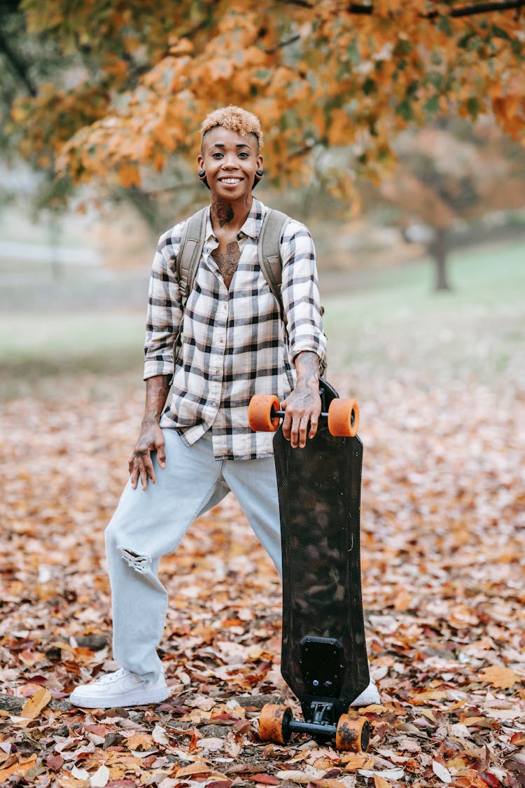 Smiling Woman With Longboard In Park