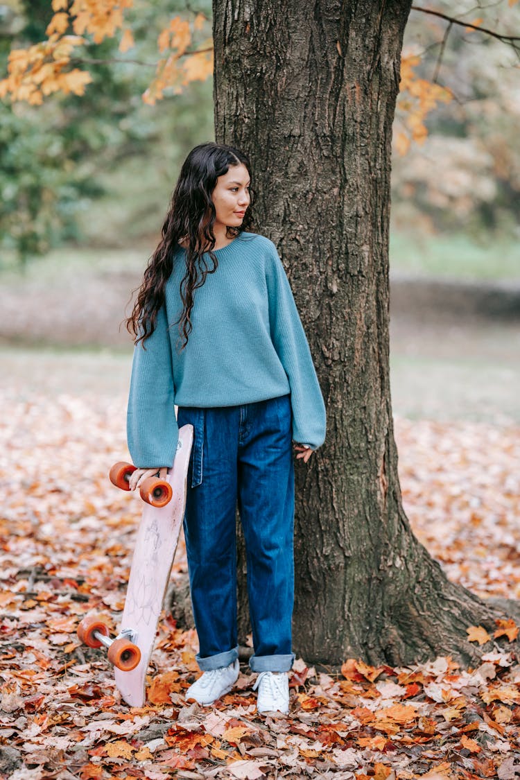 Content Hispanic Woman With Skateboard In Nature