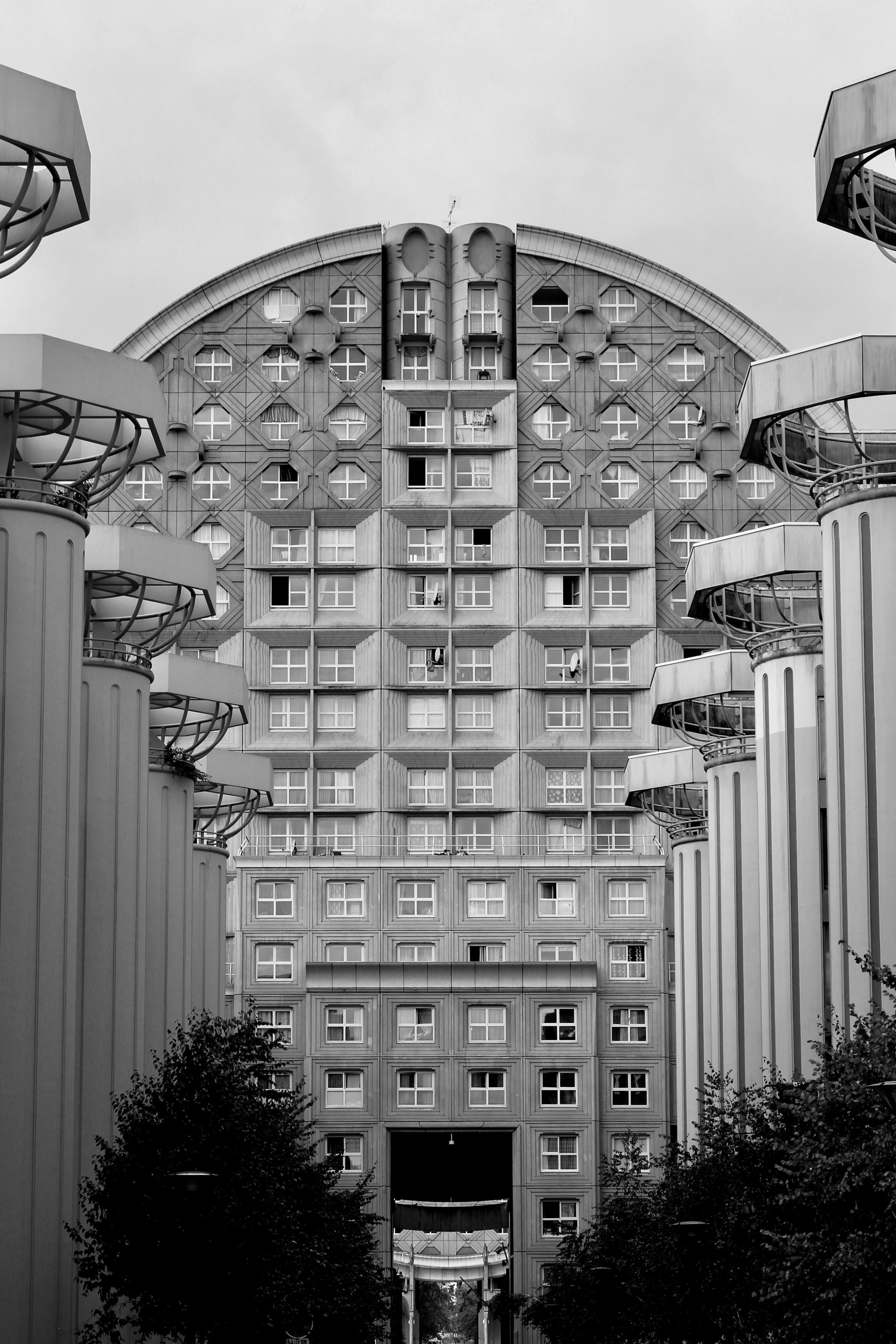 Black and white photo of a modern highrise building with geometric windows and facade.