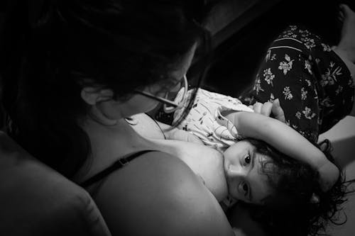 Child Breastfeeds from her Mother