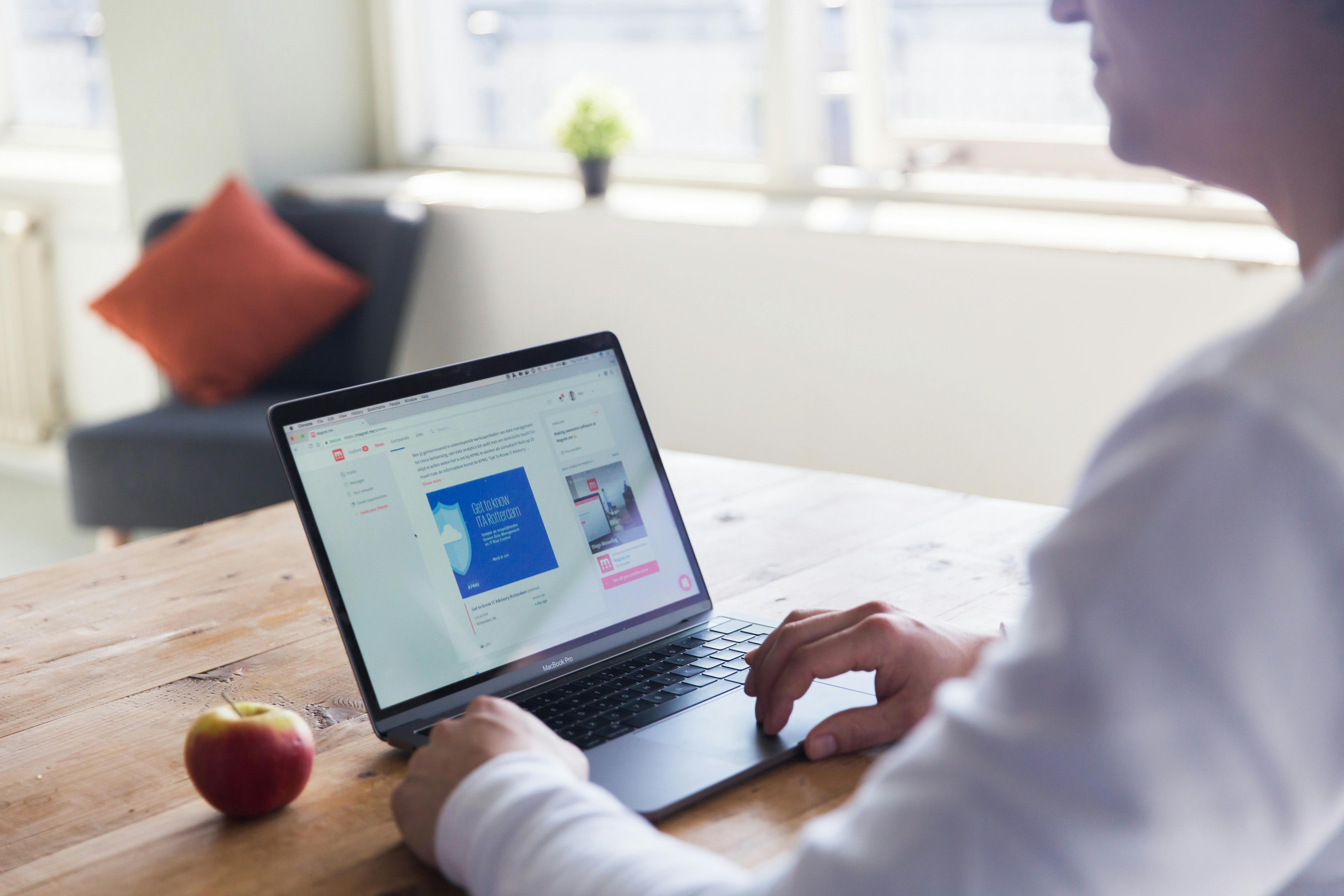 A man working remotely on a laptop in a bright home setting, emphasizing modern work lifestyle.