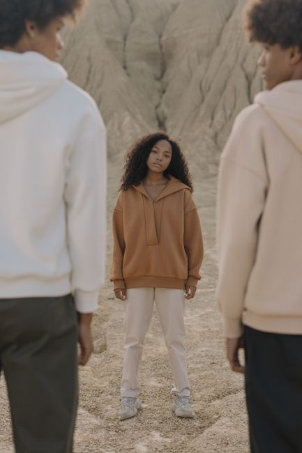 Three fashionable individuals in a desert landscape, highlighting modern trends.