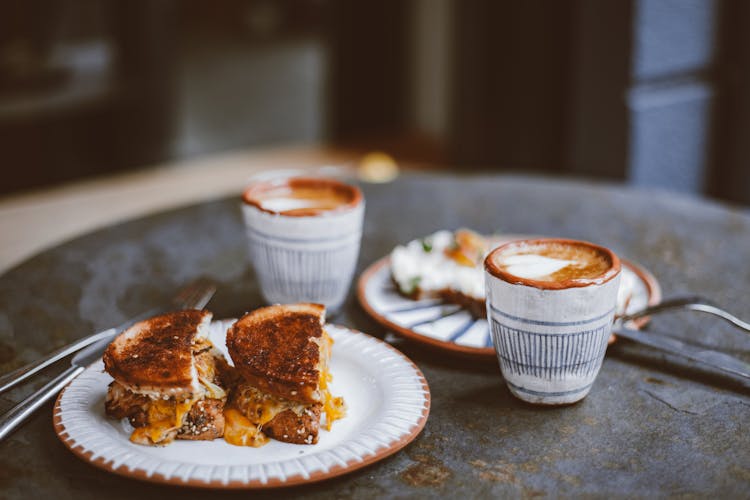 Toasted Sandwich On A Plate Near Coffee Cups On A Table