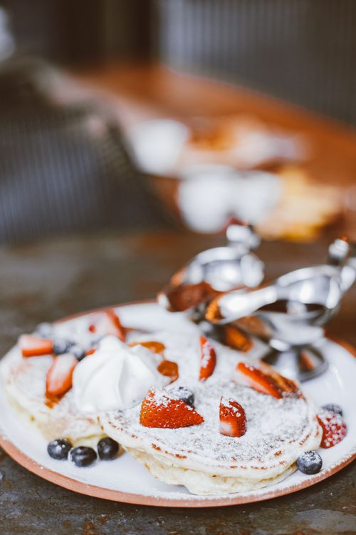 Free Delicious stack of pancakes topped with strawberries, blueberries, and whipped cream. Stock Photo