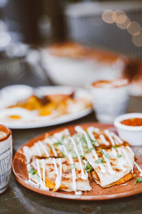 Free Tantalizing quesadillas topped with a creamy drizzle on a rustic plate, perfect for food lovers. Stock Photo