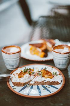 Rustic breakfast scene with artisanal bread, toppings, and two coffee cups.