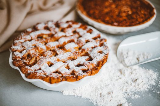 Homemade apple pie with a lattice crust, dusted with powdered sugar.
