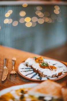 Savory breakfast toast topped with creamy spread and herbs, perfect morning meal.