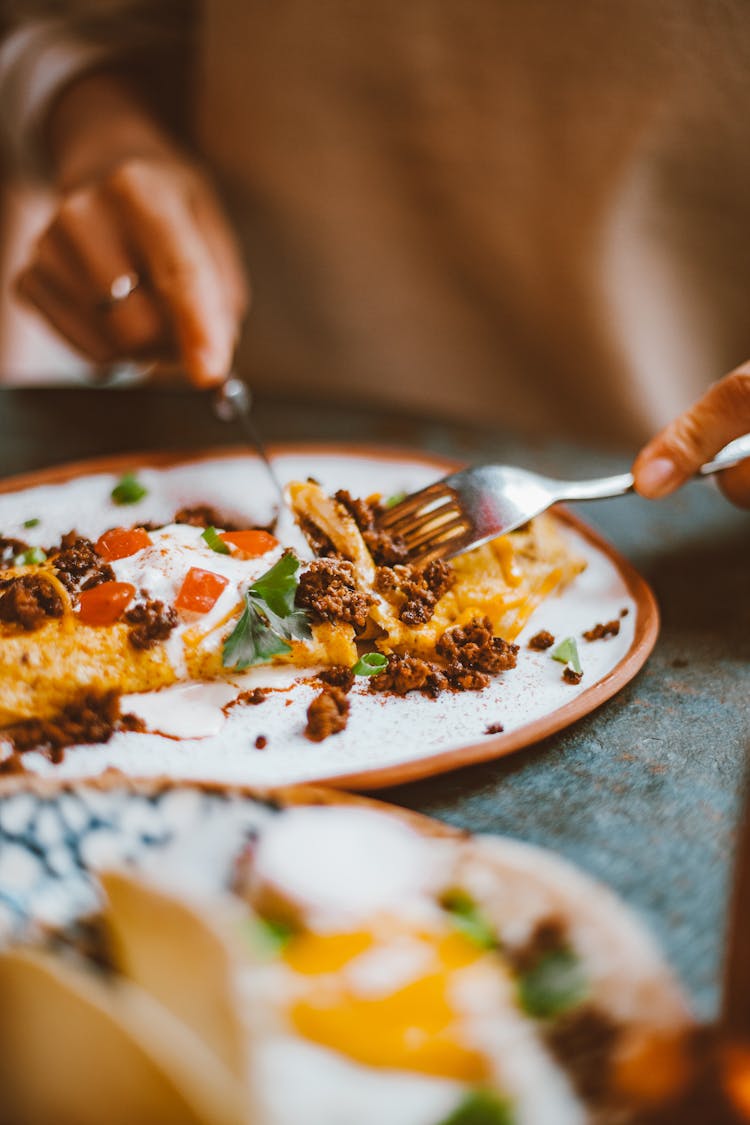 Close-up Of Woman Cutting Food On A Table 