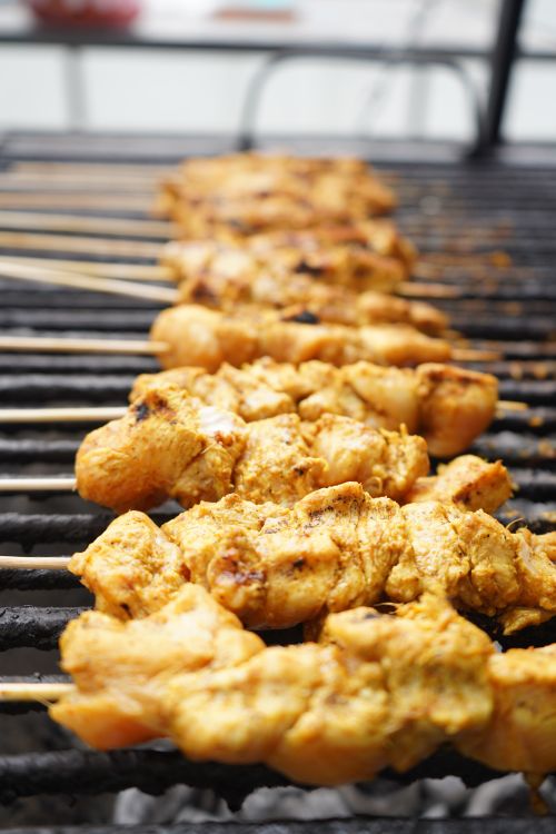 Free Close-up of juicy chicken skewers grilling over charcoal, showcasing a delicious barbecue meal. Stock Photo