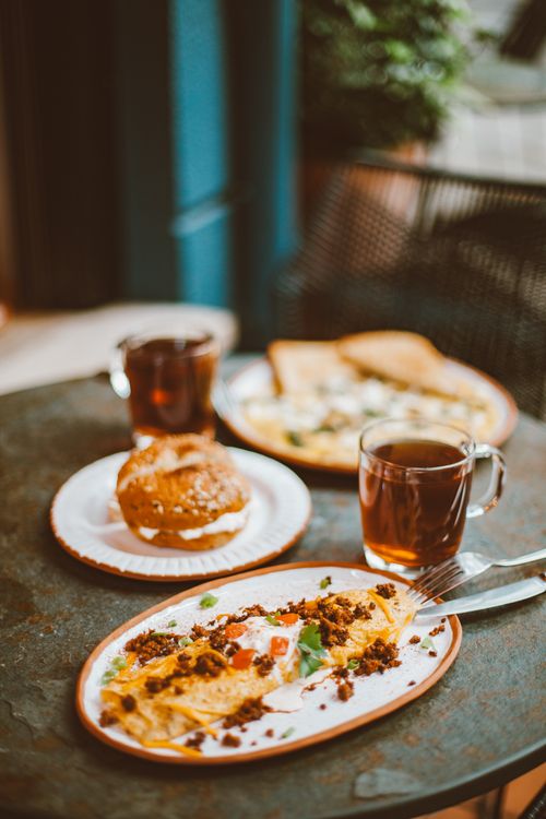 Free Warm breakfast setup with omelette and tea on an outdoor table. Stock Photo