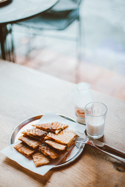 Food on a Stainless Plate Near a Glass of Milk