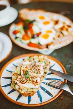 A delectable breakfast featuring avocado toast topped with microgreens and a vibrant salad with boiled eggs.