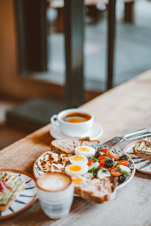 Free Hearty breakfast with eggs, salad, and coffee on a wooden table indoors. Stock Photo