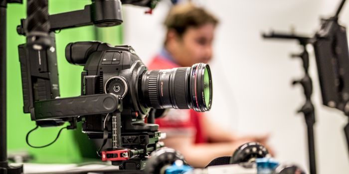 Close-up of a professional DSLR camera being used on a film set with blurred background.