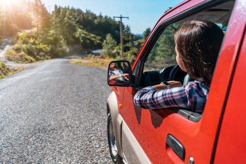 Anonymous woman driving car on road